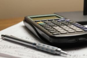 A calculator and a pen on a sheet of paper