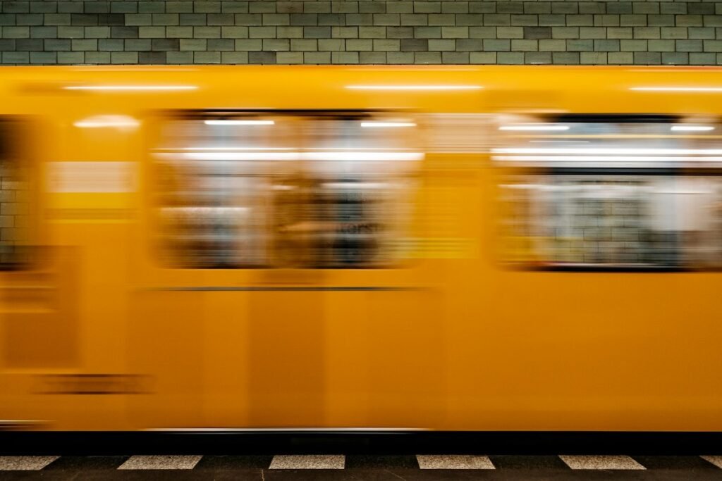 Ayellow train traveling past a train station