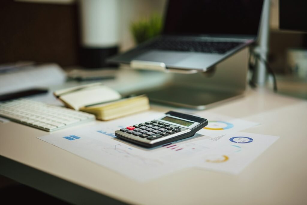 Acalculator sitting on top of a table next to a laptop